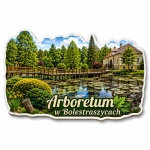Magnes pamiątkowy Arboretum w Bolestraszycach z widokiem na drzewa, staw i budynek w tle